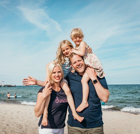 Familie mit zwei Kindern genießt Zeit am Strand