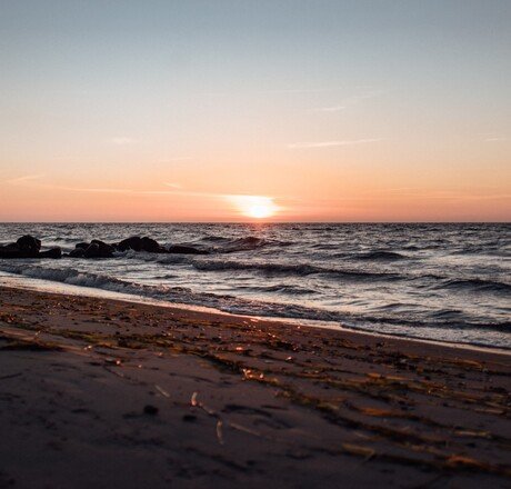 Sonnenuntergang mit Strand und Meer, roter Himmel